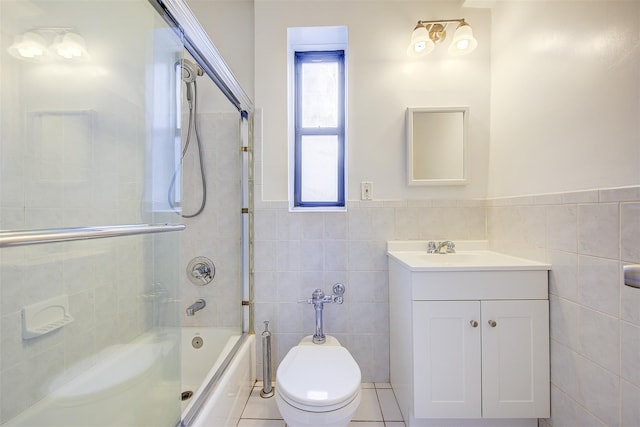 full bathroom featuring tile patterned flooring, toilet, vanity, tile walls, and  shower combination