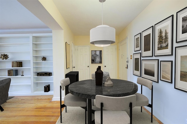 dining area featuring built in shelves and light wood-type flooring