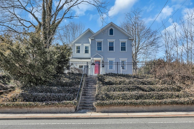 view of front of property featuring stairs and fence