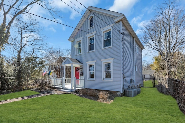 view of front of property with a front lawn, cooling unit, fence, and a gate