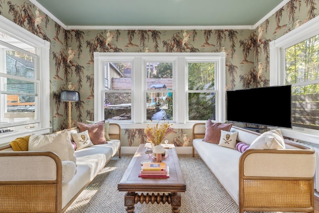 living area with ornamental molding and wallpapered walls