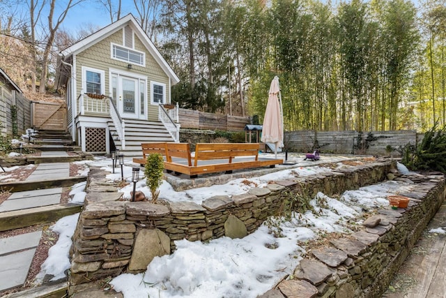 yard covered in snow featuring a deck and a fenced backyard