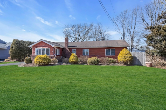 ranch-style house featuring a chimney, fence, and a front lawn