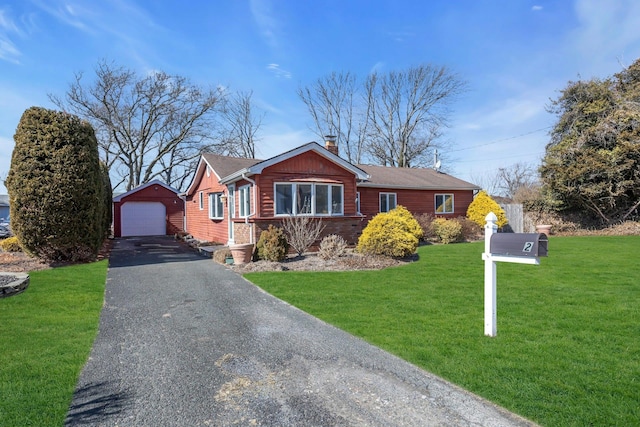 view of front of house with aphalt driveway, a garage, an outdoor structure, a chimney, and a front yard