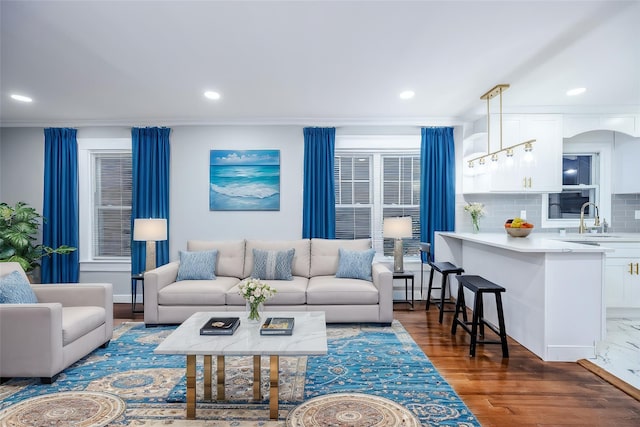 living room with ornamental molding, wood finished floors, and recessed lighting