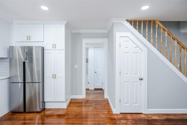 kitchen featuring recessed lighting, wood finished floors, freestanding refrigerator, and white cabinets