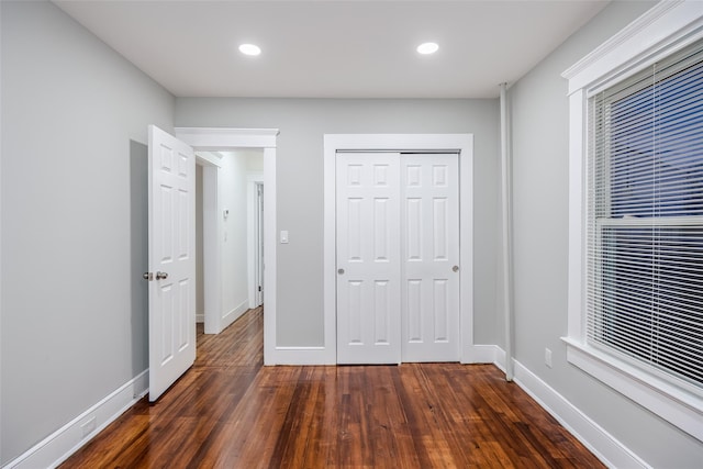 unfurnished bedroom featuring dark wood-style floors, baseboards, and recessed lighting