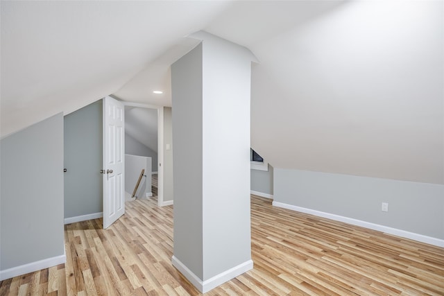 bonus room with lofted ceiling, light wood-style flooring, and baseboards