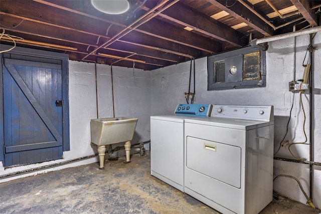 clothes washing area featuring washer and dryer, laundry area, and a sink