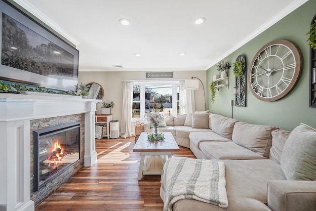 living room featuring recessed lighting, dark wood finished floors, crown molding, and a stone fireplace