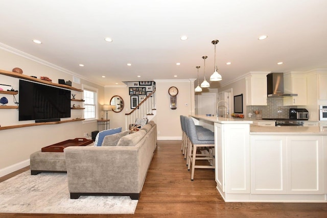 living room with baseboards, wood finished floors, and crown molding