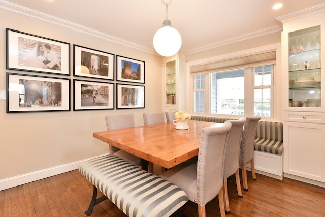 dining area with ornamental molding and wood finished floors