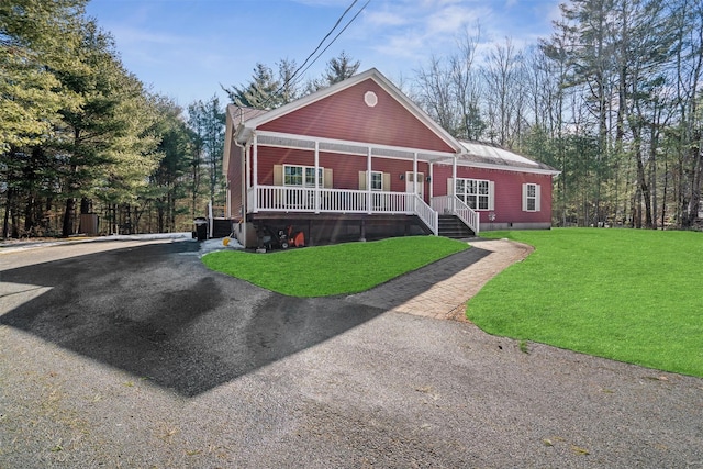 chalet / cabin with covered porch, driveway, a front lawn, and crawl space