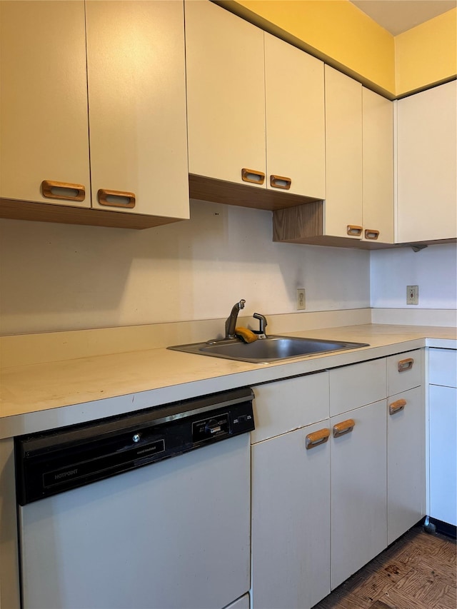 kitchen featuring wood finished floors, a sink, white cabinets, light countertops, and dishwasher