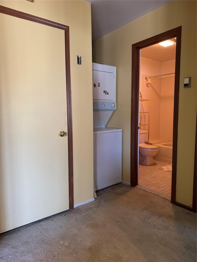 washroom with carpet floors, stacked washer and clothes dryer, and laundry area