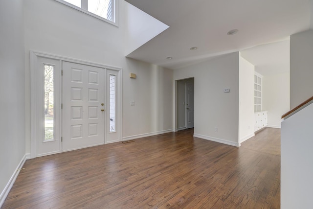 foyer entrance featuring stairway, baseboards, visible vents, and dark wood-style flooring