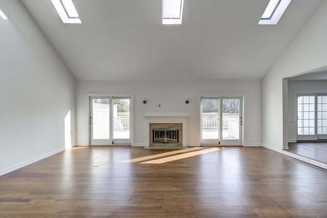 unfurnished living room featuring a fireplace, a wealth of natural light, and wood finished floors