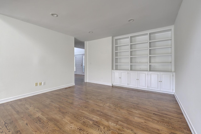 interior space featuring built in features, baseboards, dark wood-style flooring, and recessed lighting