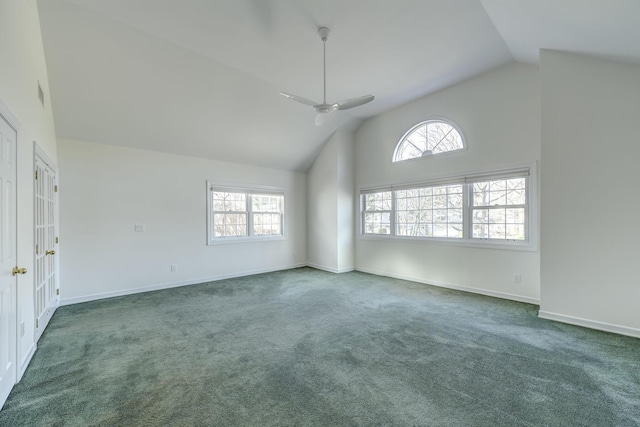 carpeted empty room with high vaulted ceiling, a ceiling fan, and baseboards