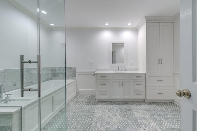 full bathroom with a wainscoted wall, a garden tub, a decorative wall, ornamental molding, and vanity