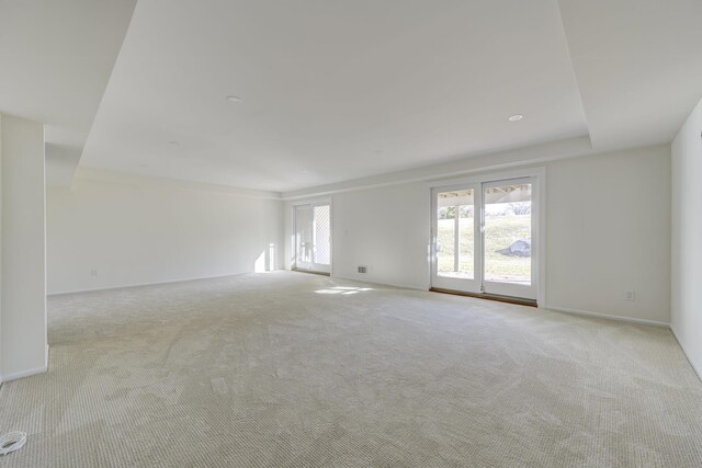 unfurnished room featuring baseboards and light colored carpet