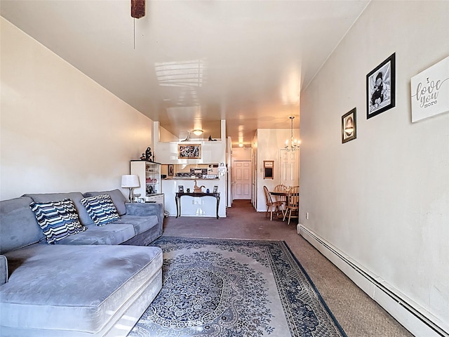 carpeted living area with baseboard heating and an inviting chandelier