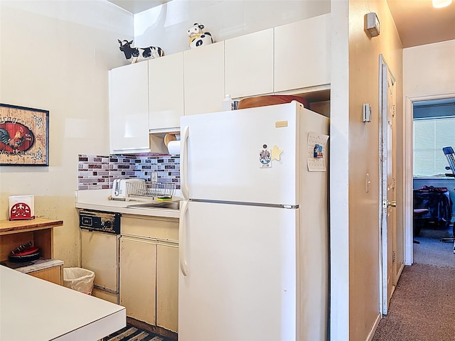 kitchen featuring tasteful backsplash, white cabinetry, freestanding refrigerator, carpet flooring, and light countertops