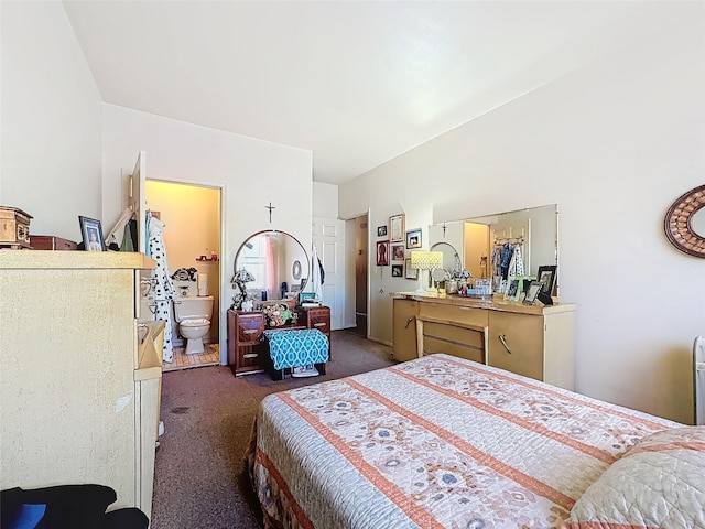 bedroom with dark carpet and ensuite bath