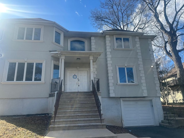 view of front of property with stucco siding, driveway, and an attached garage