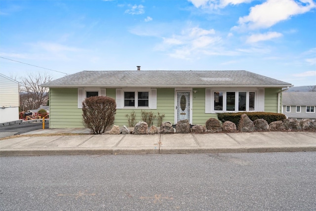 single story home with roof with shingles