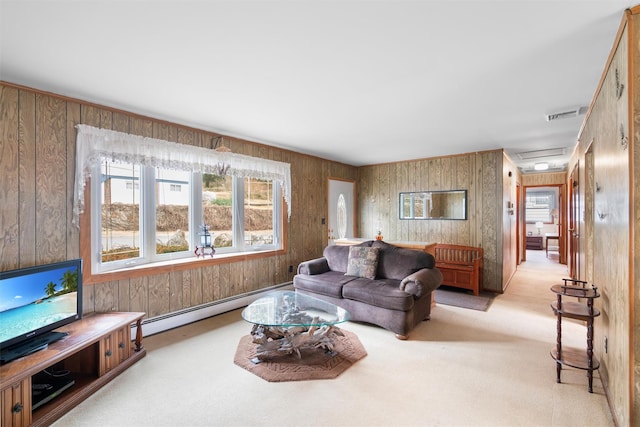 living area featuring light carpet, a baseboard radiator, wooden walls, and visible vents