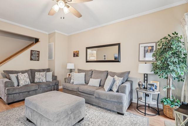 living room with baseboards, ceiling fan, wood finished floors, and crown molding