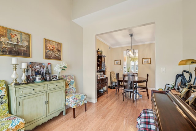 dining space featuring baseboards, crown molding, and light wood finished floors