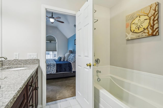 bathroom with a garden tub, lofted ceiling, ensuite bathroom, vanity, and tile patterned flooring