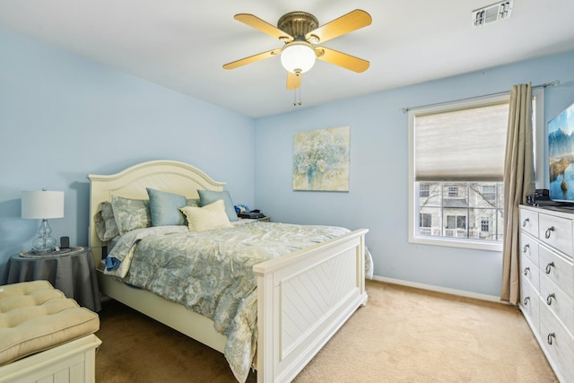 bedroom featuring baseboards, a ceiling fan, visible vents, and light colored carpet