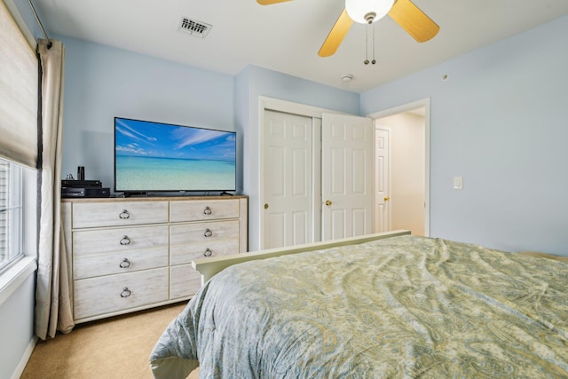 carpeted bedroom with ceiling fan, a closet, and visible vents