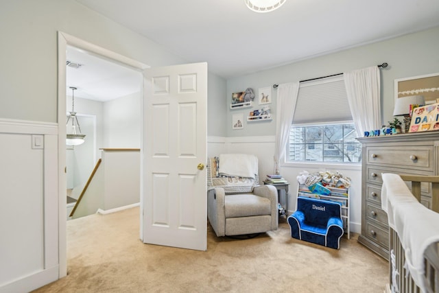 sitting room with light colored carpet, visible vents, and an upstairs landing