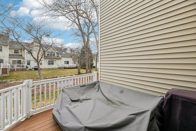 wooden deck featuring a residential view and a lawn