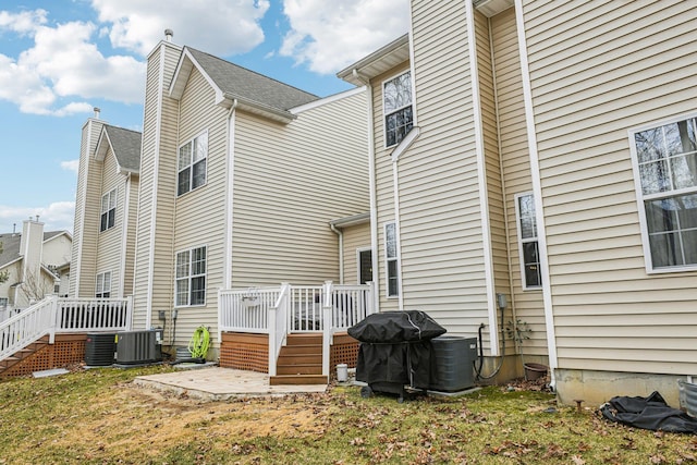 rear view of house featuring central AC and a wooden deck