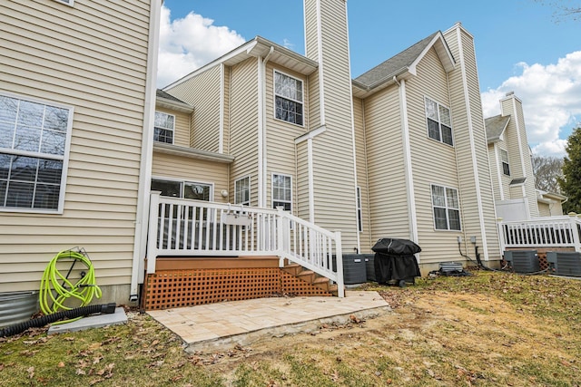 rear view of property with a deck and central air condition unit