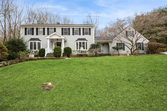 colonial home with a front lawn and a chimney