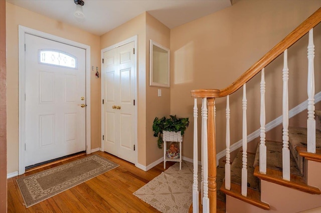 entrance foyer with stairway, baseboards, and wood finished floors