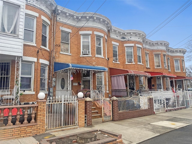 view of property featuring fence, cooling unit, and brick siding