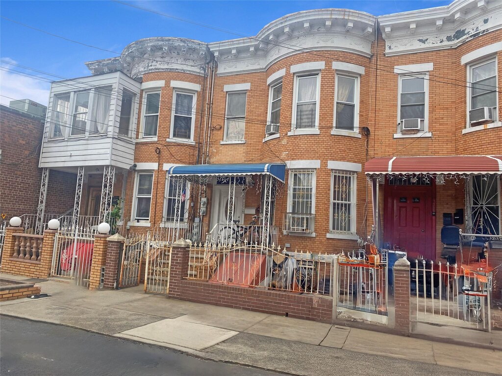 townhome / multi-family property featuring cooling unit, brick siding, and fence