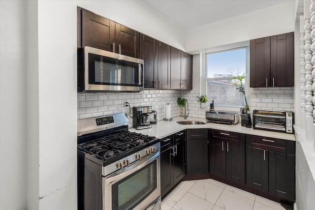 kitchen with a toaster, appliances with stainless steel finishes, tasteful backsplash, and a sink