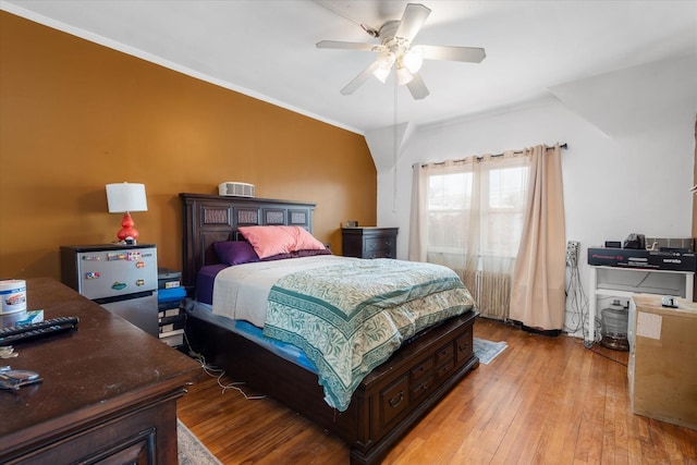 bedroom with ornamental molding, light wood-style flooring, and a ceiling fan