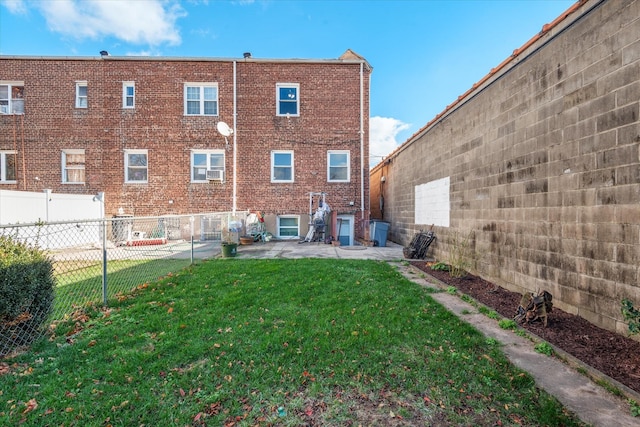 back of house with a patio, brick siding, a lawn, and a fenced backyard