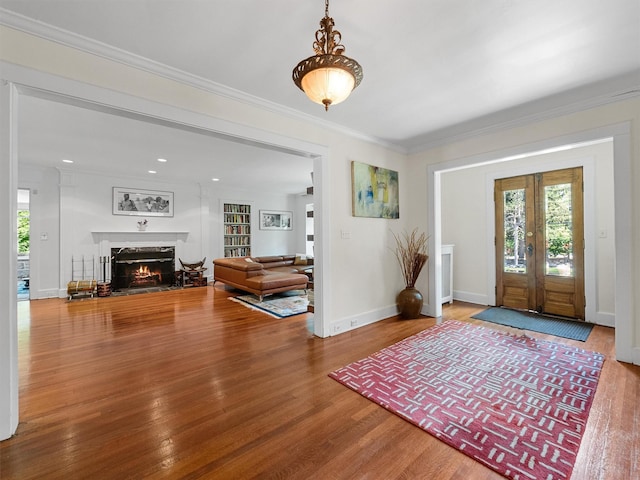 1 Finnegan Ln, Montebello, NY 10901 - entryway with wood finished floors, a lit fireplace, crown molding, and french doors
