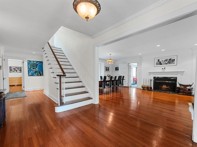 1 Finnegan Ln, Montebello, NY 10901 - living area featuring stairway, wood finished floors, a premium fireplace, ornamental molding, and a chandelier