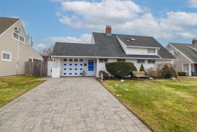 view of front of house featuring a garage, a shingled roof, a front lawn, and decorative driveway